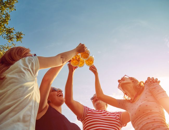 Group of young people enjoying and cheering beer outdoors. Group of young people enjoying and cheering beer outdoors.